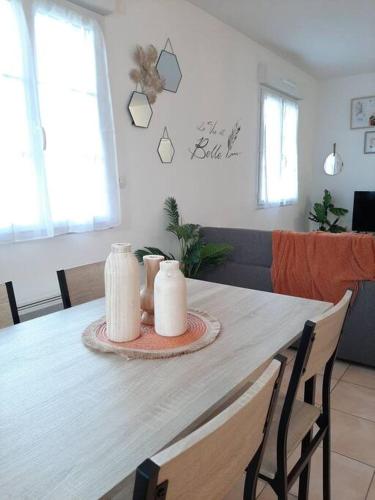 a dining room table with two candles on it at Proche aéroport à pied, O Nature in Tillé