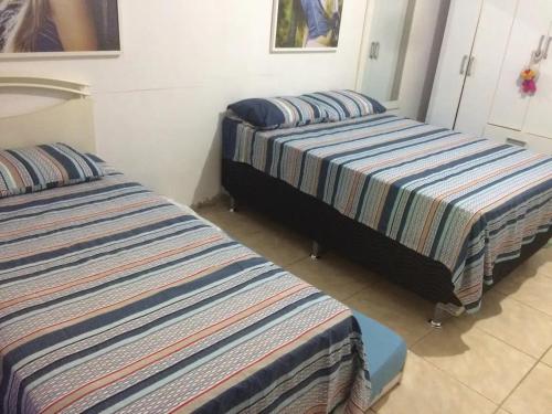 dos camas sentadas una al lado de la otra en una habitación en Residência familiar com piscina e área de lazer, en São Gabriel
