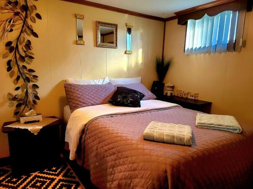 ein Schlafzimmer mit einem Bett und einer Handtasche darauf in der Unterkunft Gîte du passant SADM, parc de la Gaspésie. in Sainte-Anne-des-Monts