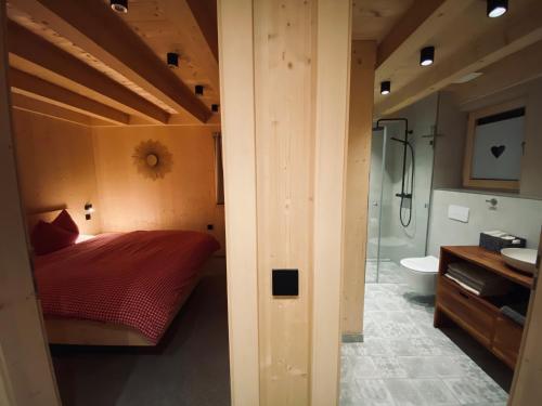 a bedroom with a bed and a bathroom with a shower at Ferienhaus Königsdorf - Urlaub im Tölzer Land in Königsdorf