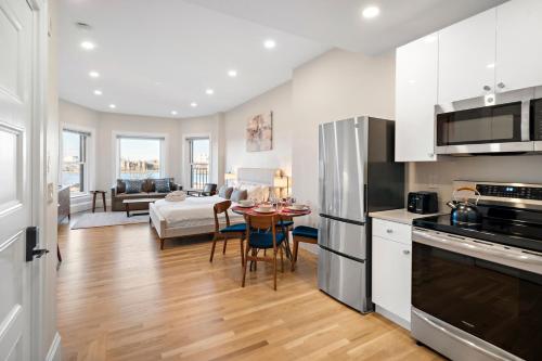 a kitchen with white cabinets and a table with chairs at Charlesgate Suites in Boston