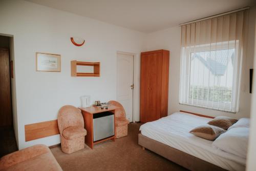 Un dormitorio con una cama, un escritorio y una silla. en Wiking, en Jastrzębia Góra