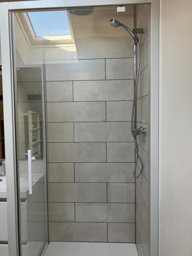 een douche met een glazen deur in de badkamer bij Etage privé in Blainville-sur-lʼEau