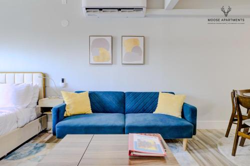 un sofá azul en una sala de estar junto a una cama en The Moose #5 - Modern Comfy Studio with King Bed, Free Parking & Fast WiFi en Memphis