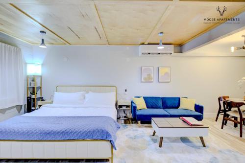 Un dormitorio con una cama y un sofá azul. en The Moose #5 - Modern Comfy Studio with King Bed, Free Parking & Fast WiFi, en Memphis