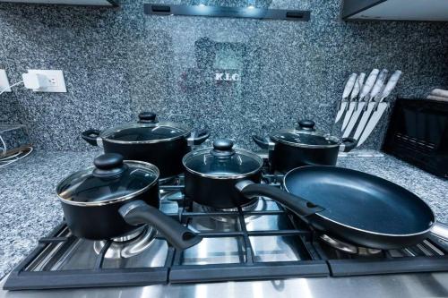 a group of pots on a stove in a kitchen at Modern 2BR in La Trinitaria Sti No in Santiago de los Caballeros
