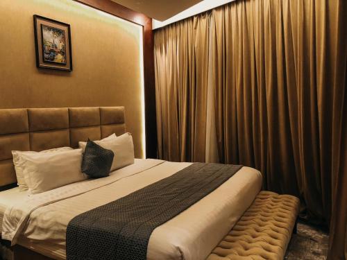 a bedroom with a large bed and curtains at فندق فيلي للشقق الفندقية Filly Hotel Apartments in Hail