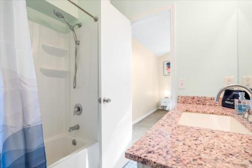 La salle de bains est pourvue d'un lavabo et d'une douche. dans l'établissement Unlimited Towels - Near Dwntwn & Tybee - Spacious Home, à Savannah