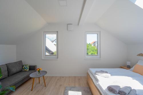 ein weißes Zimmer mit einem Bett und einem Sofa in der Unterkunft Dovolenkový dom TatraGarden Soul in Gerlachov