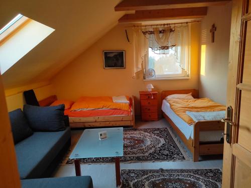 a attic room with two beds and a couch at Bella Vendégház in Székesfehérvár