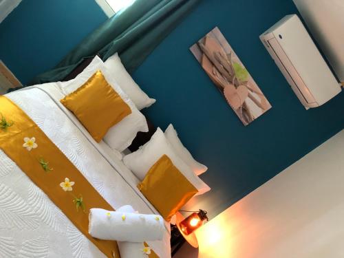 a bedroom with a bed with yellow and white pillows at Coin paisible du nord in Acoua