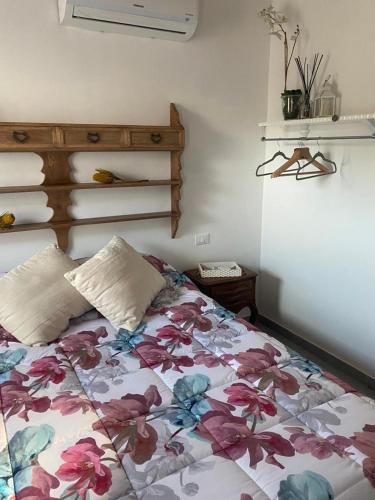 sypialnia z łóżkiem z narzutą kwiatową w obiekcie EDERA w mieście Settimo