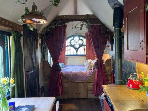 a bedroom with a bed in a room with a window at Enchanting Hand Painted Tabernacle with Hot Tub in Bude