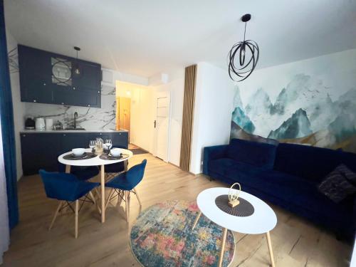 sala de estar con 2 mesas y sofá azul en Apartament w Białce Tatrzańskiej en Białka Tatrzanska