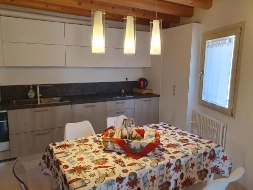 a kitchen with a table with a table cloth on it at CASA TOFFOLI SOLIGO - locazioni turistiche in Soligo