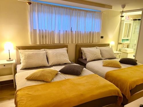um quarto com 2 camas com lençóis amarelos e uma janela em Gran Vista Holiday Home em Gornji Mihaljevec