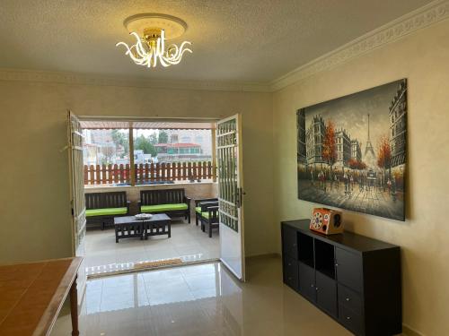 a living room with a chandelier and a living room with a table at Gather 'n' Gab Gateway family apartment in Amman