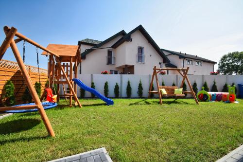 a yard with playground equipment in front of a house at Viss Mielno in Mielno
