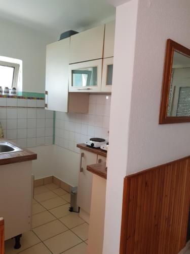 a small kitchen with white cabinets and a sink at Müllers Ferienhäuser Gunaras & Harmonie in Gunaras in Dombóvár
