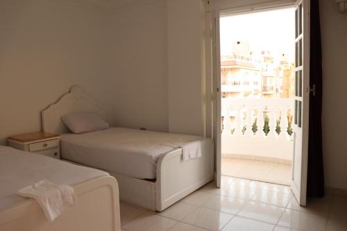 a bedroom with two beds and an open door at Falcon heaven in 6th Of October