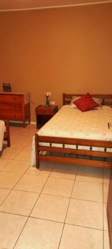 Un dormitorio con una cama con una almohada roja. en B&B Hogar Bella Vita, en Coquimbo