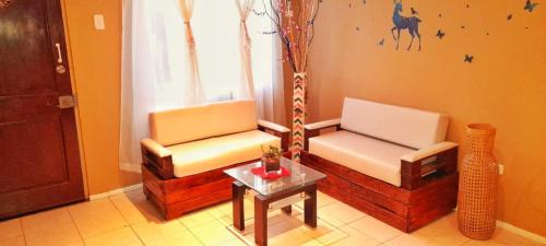 sala de estar con 2 sillas y mesa en B&B Hogar Bella Vita, en Coquimbo
