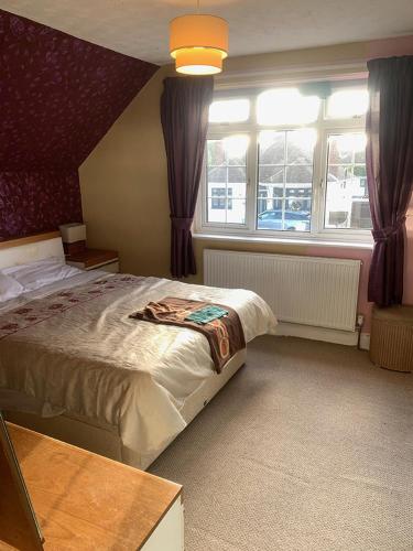 ein Schlafzimmer mit einem großen Bett und einem Fenster in der Unterkunft Coastal home in Kent