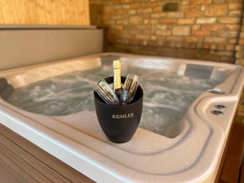 a cup of tooth brushes in a jacuzzi tub at Balaton Apartman in Balatonmáriafürdő