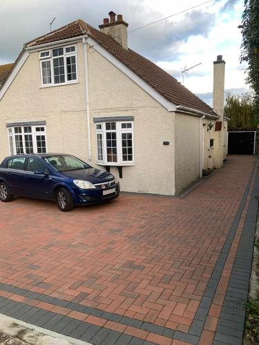 a blue car parked in front of a house at Coastal home in Kent