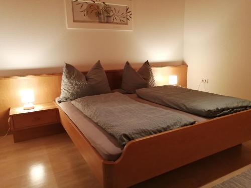 a bedroom with a wooden bed with two pillows at Haus Margreitter in Wald am Arlberg