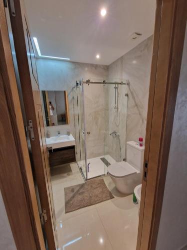 een badkamer met een douche, een toilet en een wastafel bij Luxe Appartement in Tetouan in Tetouan