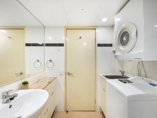 a white bathroom with a sink and a shower at Good Value Convenient City Central 2BR Apt in Brisbane