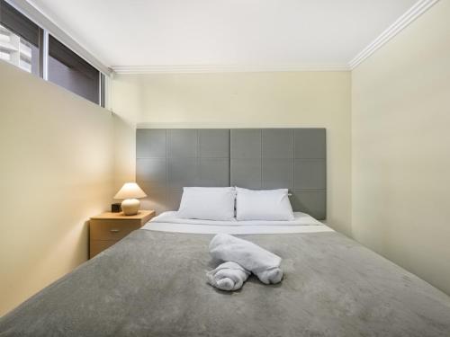 a bedroom with a bed with a towel on it at Good Value Convenient City Central 2BR Apt in Brisbane