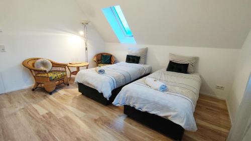 a bedroom with two beds and a chair and a window at Traumschlösschen in Nossen