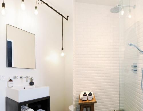 a white bathroom with a sink and a mirror at Het Raadhuys - design B&B in Kessel