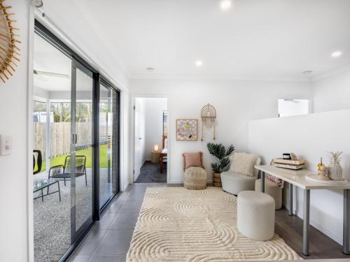 a living room with white walls and glass doors at 4BR Newly furnished Cozy house Brownsplain in Browns Plains