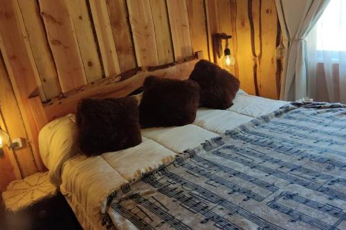 una cama con almohadas en una habitación en Cabaña Rustica, Lago/bosque/Puerto/Estufa Pellet, en Puerto Fuy