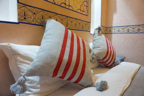 a bed with two pillows on top of it at Flowers riad in Marrakech