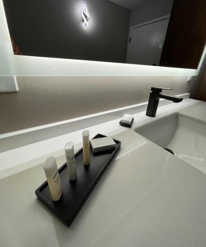 a bathroom sink with a black tray with three candles at Luxor Inn & Suites, a Travelodge by Wyndham in Elkins