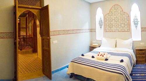 a bedroom with a bed and an open door at Flowers riad in Marrakech