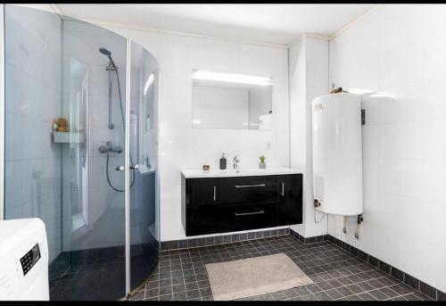 y baño blanco con lavabo y ducha. en Modern 2-bedroom apartment, 