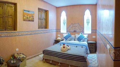 a bedroom with a bed with blue and white sheets at Flowers riad in Marrakech
