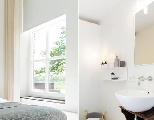 een witte slaapkamer met een wastafel en een raam bij Het Raadhuys - design B&B in Kessel