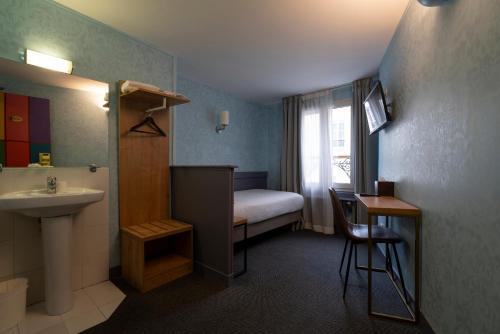 - une petite salle de bains avec un lavabo et un lit dans l'établissement Walled off Hotel Paris, à Paris