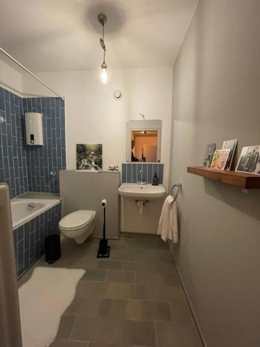 ein Badezimmer mit einem WC, einem Waschbecken und einer Badewanne in der Unterkunft Jonnys ArtApartment in Osnabrück