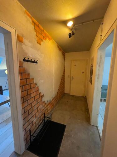 una camera con un muro di mattoni accanto a una porta di Jonnys ArtApartment a Osnabrück