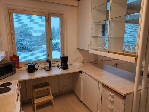 eine Küche mit Arbeitsflächen aus Holz und einem Fenster in der Unterkunft Suuri huoneisto isommalle ryhmälle / Large apartment for bigger group in Tampere