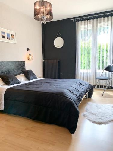 une chambre avec un grand lit et une grande fenêtre dans l'établissement Villa 3 chambres parking et terrasse, à Plaisance-du-Touch