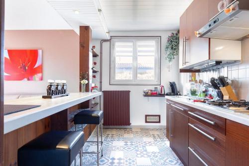 une grande cuisine avec un comptoir et une fenêtre dans l'établissement Villa 3 chambres parking et terrasse, à Plaisance-du-Touch