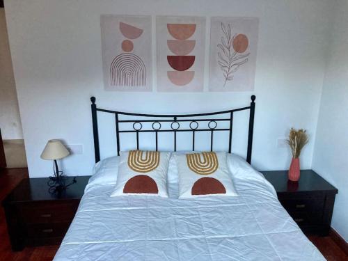 uma cama com duas almofadas num quarto em Apartamento con jardín y piscina temporada verano privados em Samieira